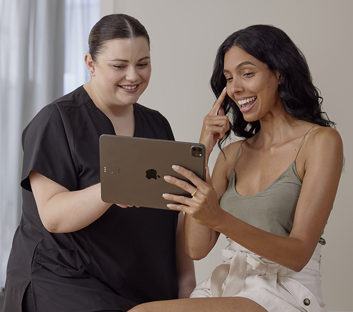 Illustrative practitioner and client reviewing a tablet